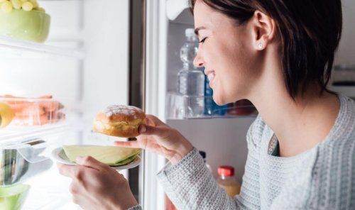 źle zbilansowana dieta może prowadzić do podjadania - kobieta jedząca pączka