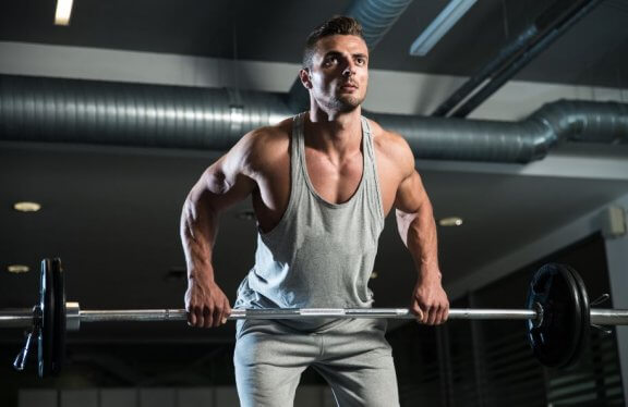 Mężczyzna robiący barbell row czyli wiosłowanie sztangą