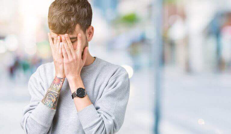 Smutny mężczyzna zakrywający twarz