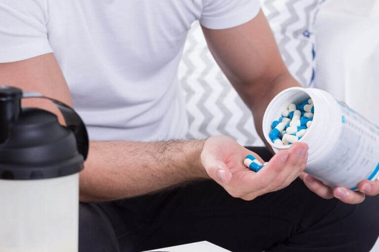 Mężczyzna wysypujący tabletki na rękę