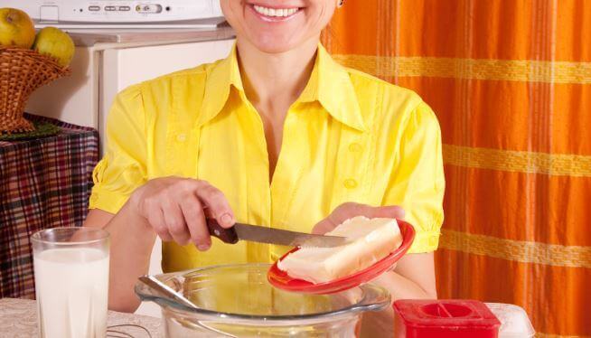 kobieta smaruje kanapkę margaryną