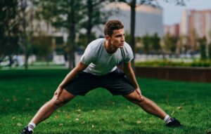 Mężczyzna w rozkroku rozciąga się rozgrzewka