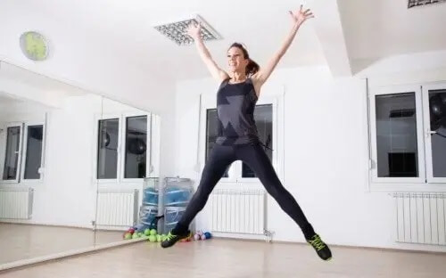 Kobieta robiąca pajacyki - ćwiczenia do wykonywania w domu