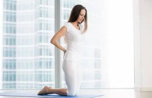 Kobieta trzymająca się za plecy